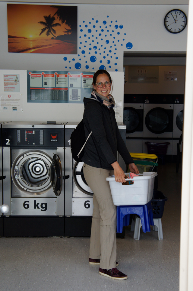 Frau wäscht Stoffwindeln im Waschsalon